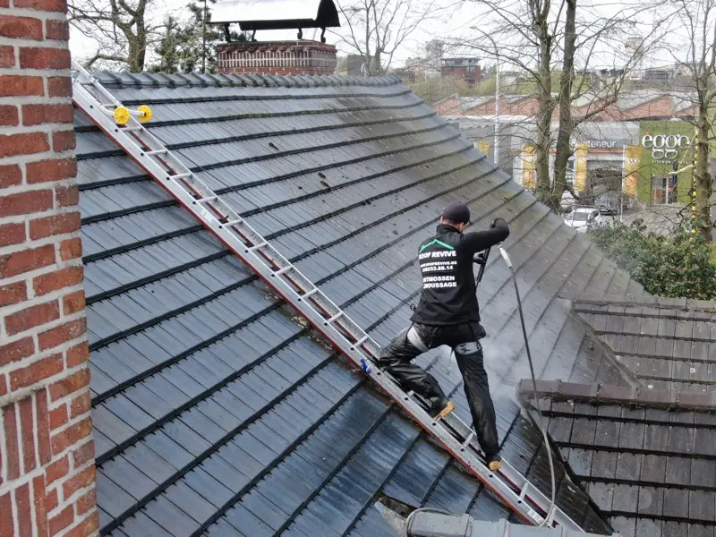 Roof Revive dakspecialist met branded werkkleding reinigt een dak