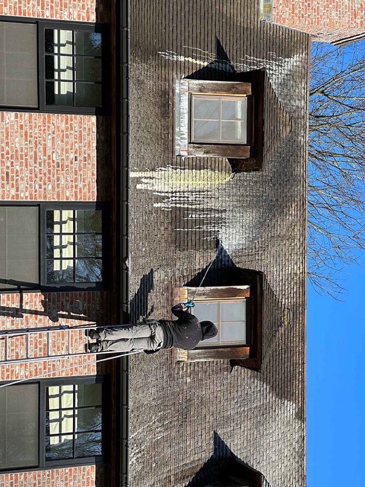 Roof Revive specialist behandelt een leien dak met lagedruk-stoommethode